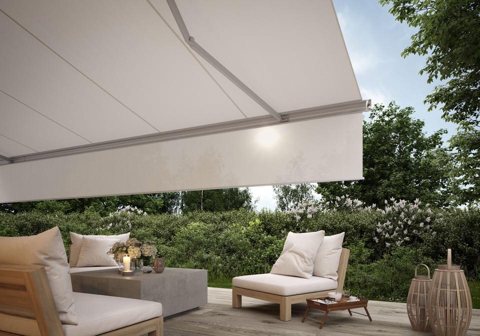 Schattenplus der markilux 6000: senkrechtes Tuch fährt aus dem Ausfallprofil über eine Loungeterrasse