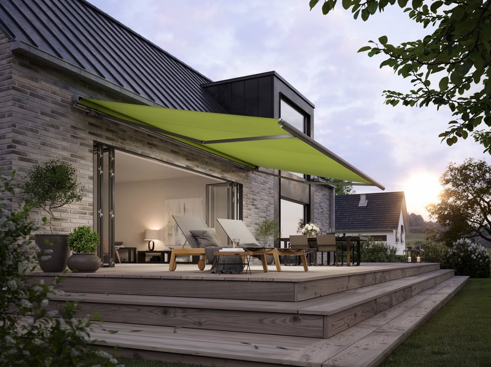 Halbkassettenmarkise markilux 1600 mit grünem Tuch über einer Holzterrasse am Einfamilienhaus, Abendstimmung